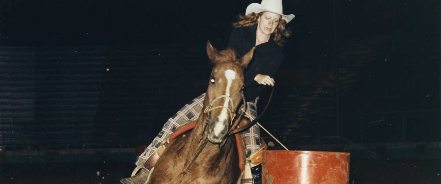 Reba rides horse around barrel